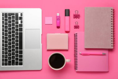 Dizüstü bilgisayarlı kompozisyon, bir fincan kahve, kırtasiye malzemesi ve pembe arka planda modern flash bellek.