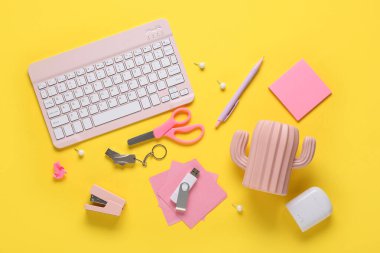 Sarı arkaplanda klavye, kırtasiye ve modern flaş bellek bileşimi