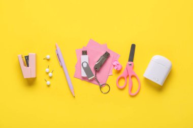 Sarı zemin üzerinde kırtasiye malzemesi ve modern flaş bellek kompozisyonu