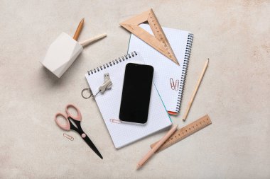 Gri grunge arkaplan üzerinde cep telefonu, kırtasiye ve modern flaş bellek bileşimi