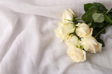 Beyaz kumaş arka planda güzel gül çiçekleri