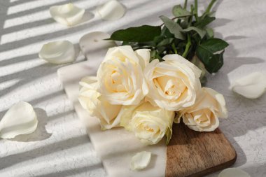 Beyaz arkaplanda güzel gül çiçekleri olan tahta