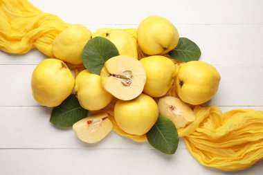 Tatlı olgun ayva ve yapraklar beyaz ahşap arka planda