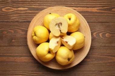 Ahşap zemin üzerinde tatlı olgun ayva tabağı