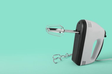 Turkuaz arka planda krom yengeçli elektrik karıştırıcı