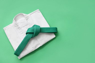 Yeşil arka planda kemeri olan karate üniforması.