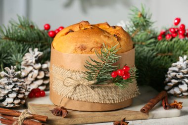 Noel panettonu, viburum dutları, tarçın çubukları, yıldız anason ve köknar ağacı dalları olan bir panet.