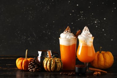 Siyah ahşap masada portakal kabaklı baharatlı latte.