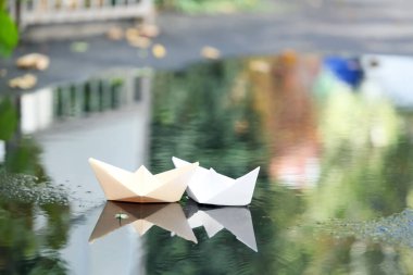 Su birikintisindeki kağıt tekneler, yakın çekim.