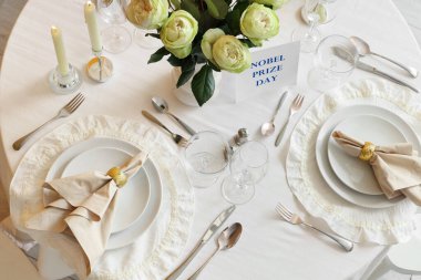 Güller ve yanan mumlarla Nobel ödül günü için masa ayarları, üst manzara.