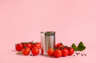 Domates ezmeli teneke kutu ve pembe arka planda malzemeler.