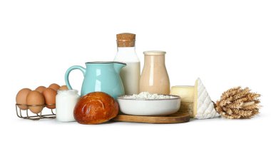 Beyaz arka planda çörek, yumurta ve buğday dikenli farklı süt ürünleri.