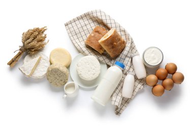 Ekmek, yumurta, buğday filizi ve beyaz arka planda peçete içeren süt ürünleri.