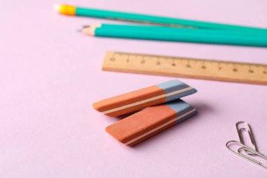 Leylak arkaplanında kalem ve cetvel olan silgi.