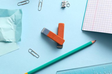 Mavi arkaplanda farklı kırtasiye malzemesi olan silgiler