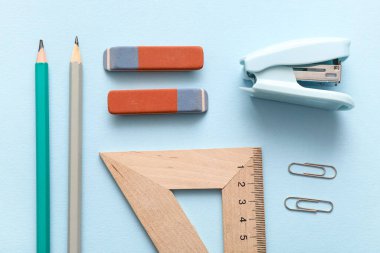 Mavi arkaplanda farklı kırtasiye malzemesi olan silgiler