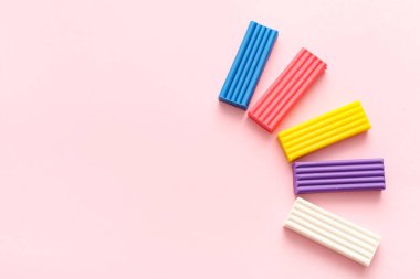 Pembe arka planda renkli plastikler