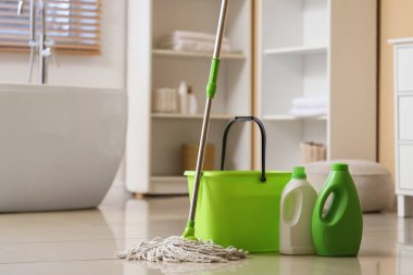 Kova ile paspas ve banyoda fayans zemininde deterjan