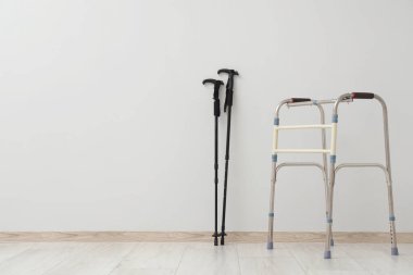 Tıbbi yürüteç ve yürüme direkleri odada ışık duvarının yanında.