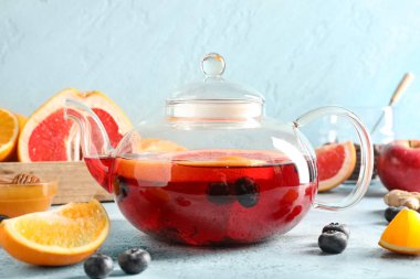 Mavi grunge masasında bir bardak lezzetli meyve çayı, yakın plan.