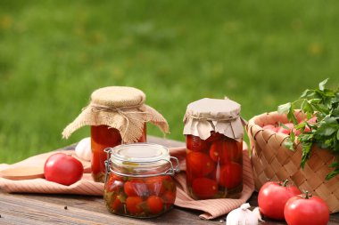 Sarımsak ve maydanozlu konserve domates kavanozları.