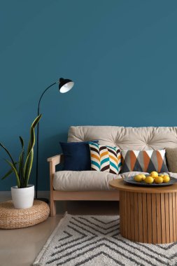 Rahat kanepe, standart lamba ve kahve masasında limonlar olan şık bir oturma odası.