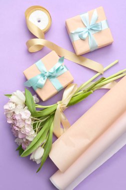 Paket kağıtlı hediye kutuları, bir buket lale ve mor arka planda ortanca çiçekleri. Uluslararası Kadınlar Günü