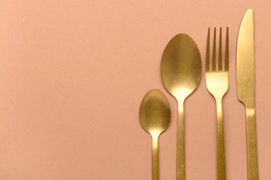 Bej arka planda temiz altın çatal bıçak takımı