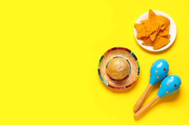 Meksika marakası, sombrero ve sarı arka planda nacho. Cinco de Mayo