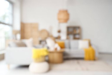 Oturma odasının bulanık manzarası, rahat gri koltuklar ve kahve masası.