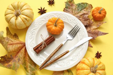 Taze balkabakları, yıldız anason, tarçın ve sarı arka planda sonbahar yapraklarıyla güzel bir masa.