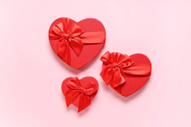 Pembe arka planda kalp şeklinde hediye kutuları. Sevgililer Günü kutlaması