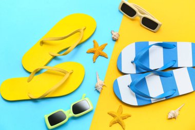 Renkli arka planda deniz kabukları, güneş gözlüğü ve parmak arası terlik kompozisyonu