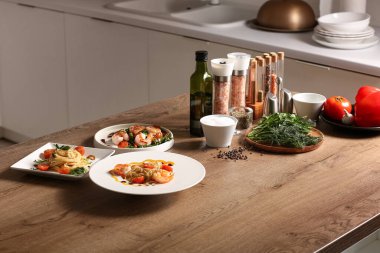 Mutfaktaki masada lezzetli makarna ve karidesli tabaklar, yakın plan.