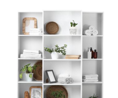 Temiz havlular ve beyaz arka planda bitkiler olan raf ünitesi.