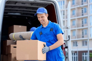 Erkek nakliyeci sokakta kutuları boşaltıyor