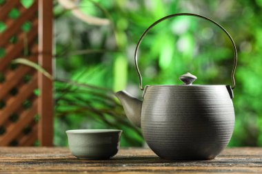 Seremoni için bir fincan çay ve çaydanlık dışarıda, ahşap masada, yakın plan.