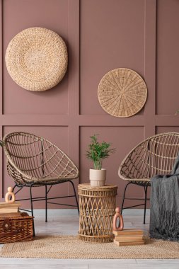 Hasır koltuklu, masa ve bitki dolu bir oda.