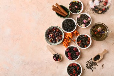 Pembe arkaplanda farklı kuru meyve çayları içeren kompozisyon