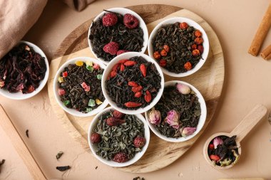 Bej rengi grunge arka planda farklı kuru meyve çayları, yakın plan.