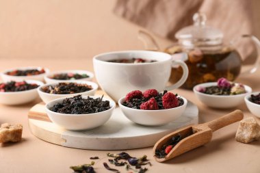 Bej grunge masasında farklı kuru meyve çayları, yakın plan.