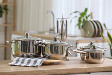 Mutfaktaki masada paslanmaz tencere ve çatal bıçak.