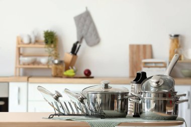 Mutfaktaki masada paslanmaz tencere ve rende var.