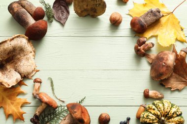 Taze mantardan yapılmış çerçeve, balkabağı ve sonbahar yaprakları yeşil ahşap arka planda, yakın plan