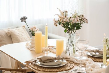 Çiçek buketi ve mumlarla dolu güzel bir masa.