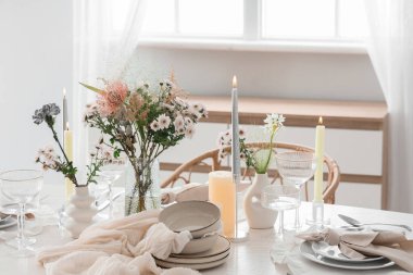 Çiçek buketi ve mumlarla dolu güzel bir masa.