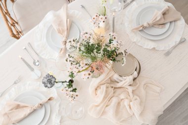 Çiçek buketi ve mumlarla dolu güzel bir masa. Hafif yemek odası, üst manzara.