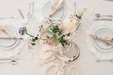 Çiçek buketi ve mumlarla dolu güzel bir masa. Hafif yemek odası, üst manzara.