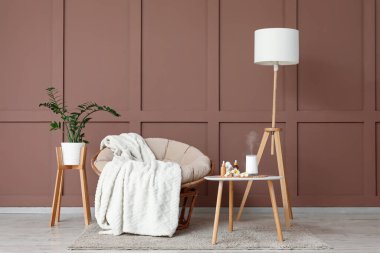 Masanın üzerinde koltuk, lamba ve aroma yayıcısı olan oturma odasının içinde.