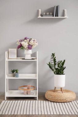 Vazoda ve raf ünitesinde leylak çiçekleri olan ışık odasının içinde.